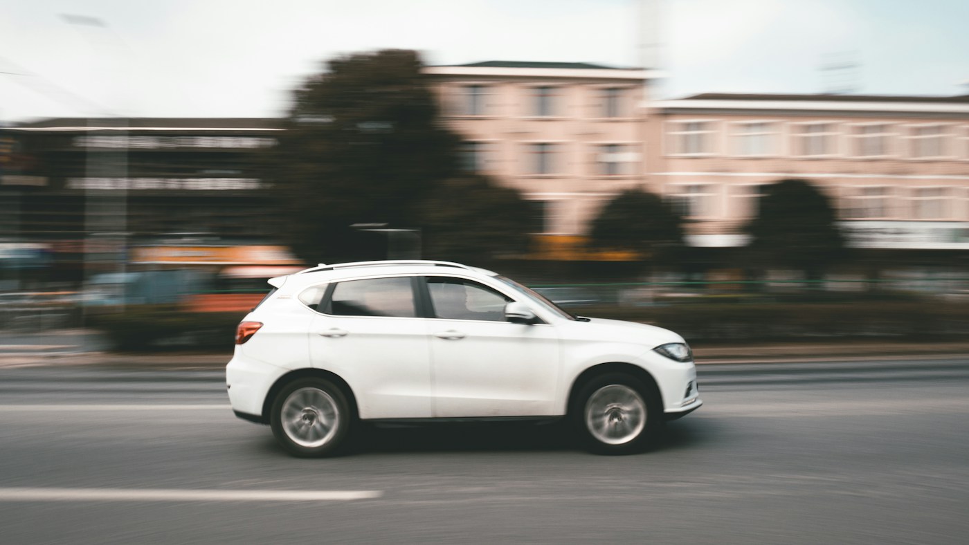 White SUV travelling along a city road